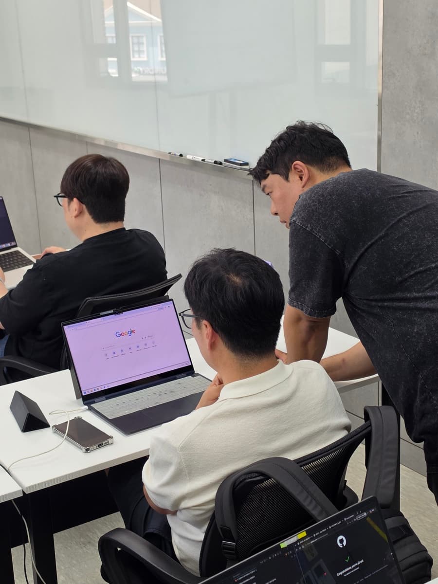 업무 자동화 과정에서 강사가 참가자 옆에서 자동화 설정을 1:1로 안내하는 모습
